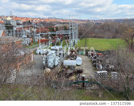 Electrical power substation infrastructure with transformer equipment cables and steel frames forming complex geometric industrial landscape. Energy distribution technology, electricity network 137311506