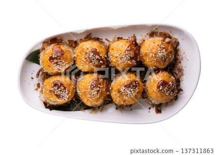 Top-down view of eight baked sushi rolls with creamy orange topping 137311863