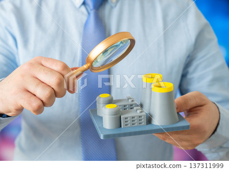 An official examines a nuclear power plant with a magnifying glass. Safety inspection and power plant design review ensuring regulatory compliance and radiation risk control. 137311999