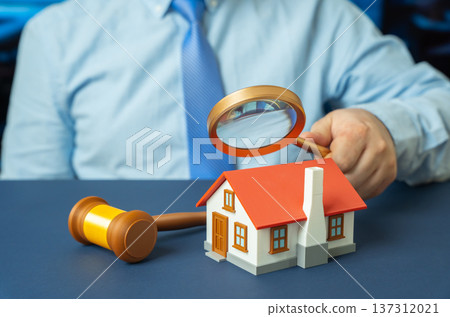 A man examines a residential building through a magnifying glass. Property appraisal and verification of transaction legality with due diligence and Real estate risk assessment. A man examines a residential building through a magnifying glass. Property appraisal and verification of transaction legality with due diligence and Real estate risk assessment. 137312021