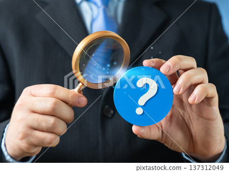 A businessman studies a problem with a magnifying glass. Search for a solution and strategic analysis to solve a complex business challenge through careful investigation. A businessman studies a problem with a magnifying glass. Search for a solution and strategic analysis to solve a complex business challenge through careful investigation. 137312049