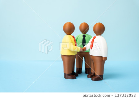 Figures of businessmen shaking hands at a meeting. Business and communication partnership concept with diversity leadership corporate cooperation and professional networking success. Figures of businessmen shaking hands at a meeting. Business and communication partnership concept with diversity leadership corporate cooperation and professional networking success. 137312058
