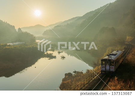 A Yodo Line diesel railcar running along the Shimanto River, Japan's last clear river, bathed in backlight from the morning sun. A Yodo Line diesel railcar running along the Shimanto River, Japan's last clear river, bathed in backlight from the morning sun. 137313087