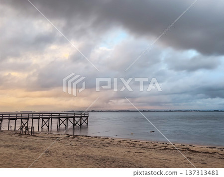Empty wooden pier with dramatic sky and calm water Empty wooden pier with dramatic sky and calm water 137313481