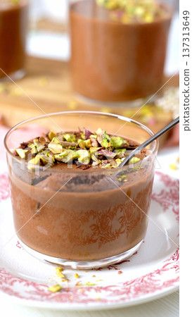 Indulgent chocolate mousse with pistachios and a spoon Indulgent chocolate mousse with pistachios and a spoon 137313649
