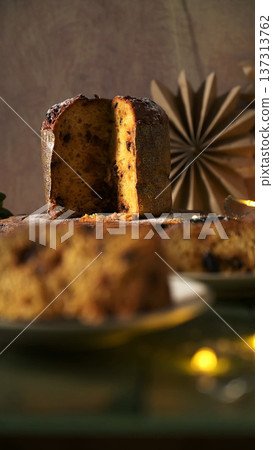 Vertical Dark Photo of Sliced Panettone with Blurred Foreground and Warm Backlight 137313762