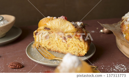 Slice of Christmas Fruit Cake with Pineapple and Nuts on a Small Plate 137313773