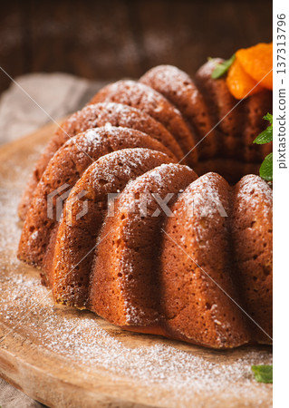 Freshly Baked Bundt Cake with Powdered Sugar and Apricot Garnish 137313796