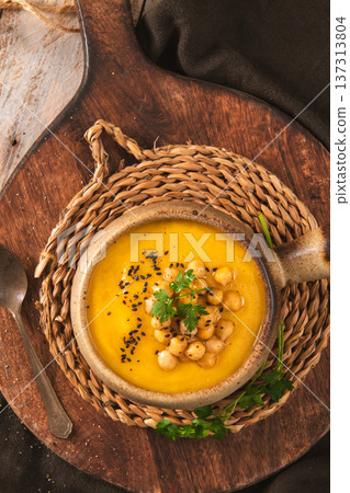Roasted Pumpkin and Carrot Soup Topped with Chickpeas and Sesame Seeds 137313804