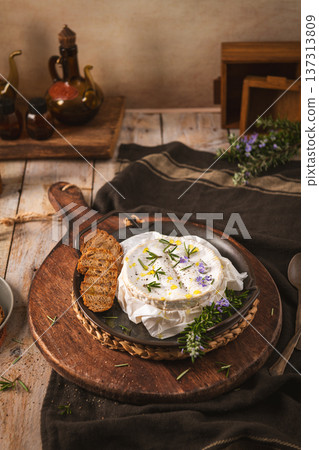 Rustic Baked Camembert Cheese with Rosemary and Toasted Bread on a Wooden Board 137313809