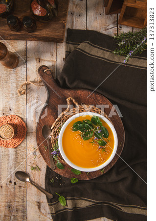 Creamy Butternut Squash Soup Topped with Fresh Spinach and Sesame Seeds 137313823