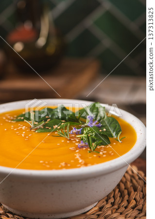 Creamy Butternut Squash Soup Topped with Fresh Herbs and Edible Flowers 137313825