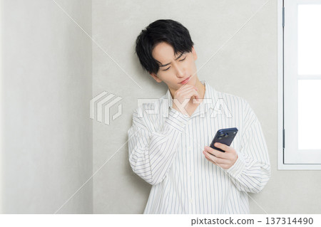 看他的智能手機的一個年輕人 看他的智能手機的一個年輕人 137314490