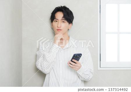 看他的智能手機的一個年輕人 137314492