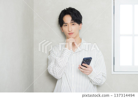 A young man looking at his smartphone 137314494