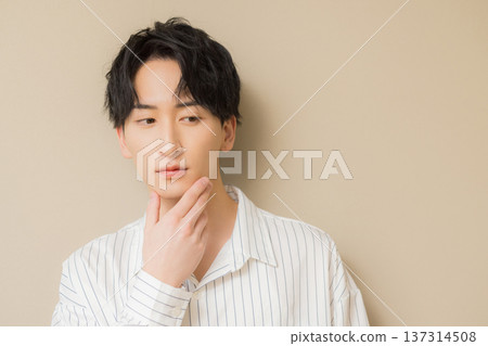 一個男人在他的下巴上打他的手 一個男人在他的下巴上打他的手 137314508
