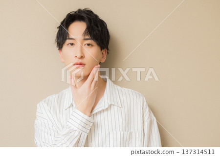 一個男人在他的下巴上打他的手 一個男人在他的下巴上打他的手 137314511