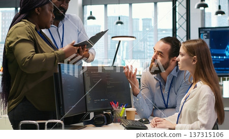 Teamworking programmers developing software applications, working together to optimize code. Tech startup team doing brainstorming in office, using AI to solve bottlenecks, camera A 137315106