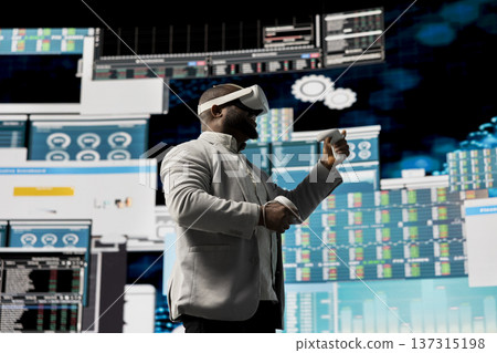 Black administrator reviewing big data with virtual reality headset, working hard on business development to increase funds. Analyzing monthly reports for productivity and success. 137315198