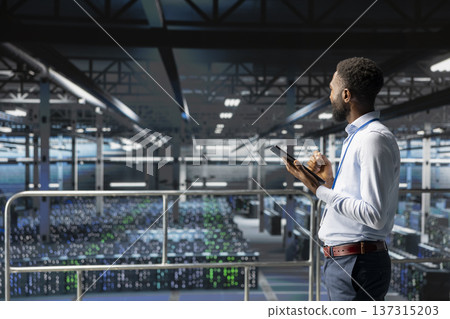 African american engineer reviews performance outputs and AI visualizations on computer. IT expert analyzing neural network to ensure stable infrastructure operations in data center. 137315203