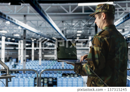 Data center army officer in uniform types commands on laptop keyboard, tracking missiles. Military server farm specialist using notebook telemetry software, confirming target lock Data center army officer in uniform types commands on laptop keyboard, tracking missiles. Military server farm specialist using notebook telemetry software, confirming target lock 137315245