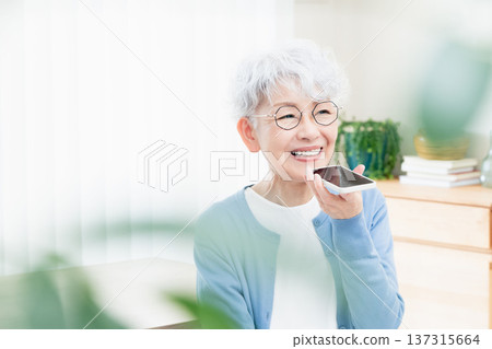 一位老年婦女正在對著智慧型手機說話 137315664