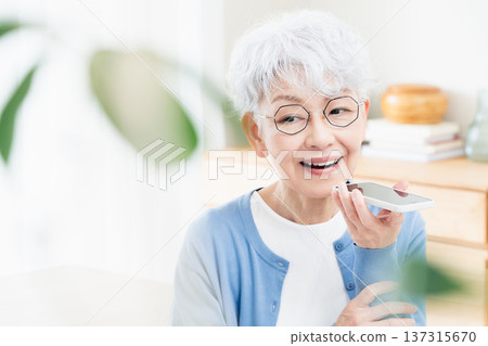 一位老年婦女正在對著智慧型手機說話 137315670