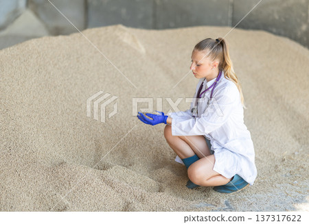 Female veterinarian checking pelleted livestock feed Female veterinarian checking pelleted livestock feed 137317622