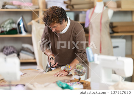 Male fashion designer cuts paper in the workshop 137317650
