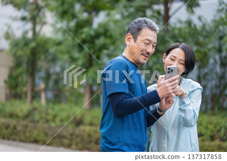 A couple manipulating a smartphone 137317858