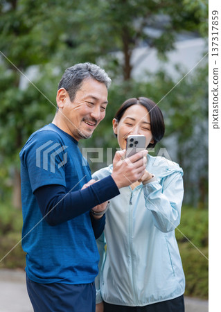 A couple manipulating a smartphone A couple manipulating a smartphone 137317859