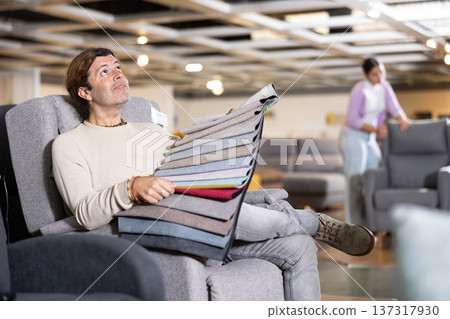 Middle-aged man chooses upholstery color of furniture Middle-aged man chooses upholstery color of furniture 137317930