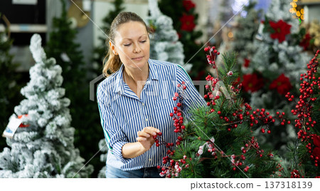 Positive woman buying christmas tree in market 137318139