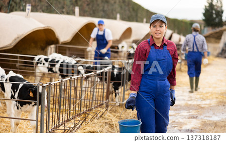 Farmer woman stands with bucket at cow farm Farmer woman stands with bucket at cow farm 137318187