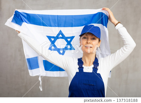 Smiling adult woman in uniform holding Israel flag Smiling adult woman in uniform holding Israel flag 137318188