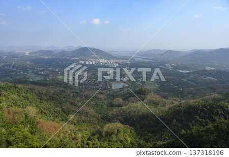 Aerial view of Sanya city with a sea bay surrounded by mountains on Hainan Island in China Aerial view of Sanya city with a sea bay surrounded by mountains on Hainan Island in China 137318196