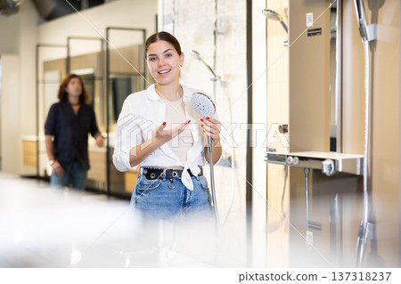 Focused woman choosing wall tiling materials in hardware shop Focused woman choosing wall tiling materials in hardware shop 137318237