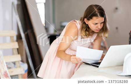 Female architect using laptop during repair works 137318280