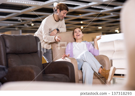 couple chooses comfortable armchair in furniture store couple chooses comfortable armchair in furniture store 137318293