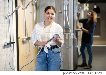 Confident woman looking to buy bathroom wall tiles in materials section of hardware store Confident woman looking to buy bathroom wall tiles in materials section of hardware store 137318299