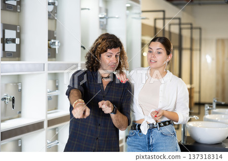 in plumbing department, couple thought about choosing suitable bathroom for new apartment in plumbing department, couple thought about choosing suitable bathroom for new apartment 137318314