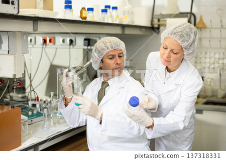 Man and woman scientists chemists conduct experiments in the laboratory Man and woman scientists chemists conduct experiments in the laboratory 137318331