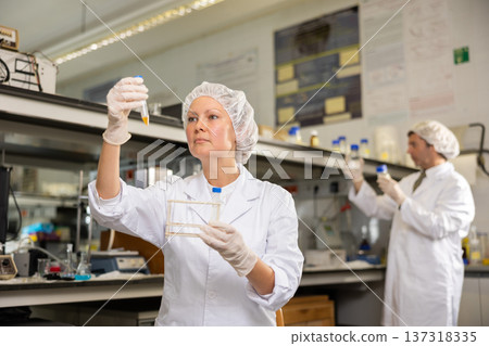 Focused female technician working in research laboratory Focused female technician working in research laboratory 137318335