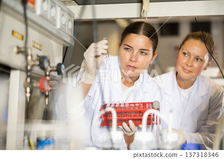Confident women technicians working in research laboratory 137318346