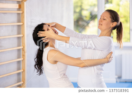 Two women training self-defense techniques in studio Two women training self-defense techniques in studio 137318391