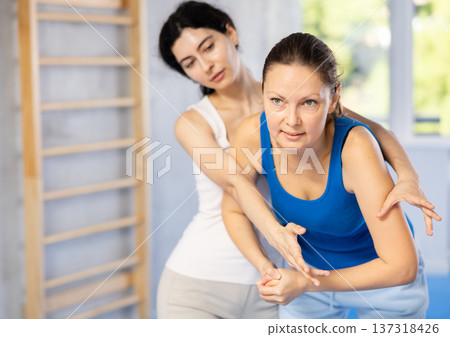 Two women training self-defense techniques in studio Two women training self-defense techniques in studio 137318426