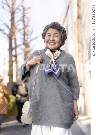 走在城市裡的微笑的高級婦女 137320272