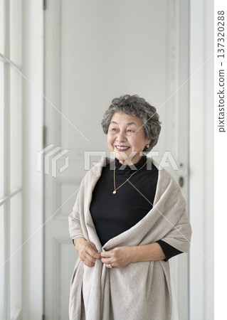 A woman in her 80s smiling by the window 137320288