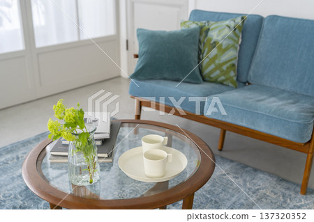 客廳圖片:一張玻璃桌上擺放著花瓶和杯子。 客廳圖片:一張玻璃桌上擺放著花瓶和杯子。 137320352