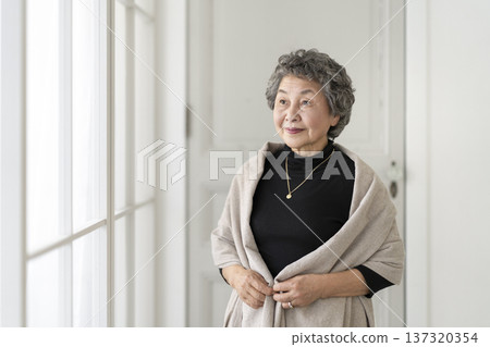 一位八十多歲的老婦人站在窗邊微笑 一位八十多歲的老婦人站在窗邊微笑 137320354